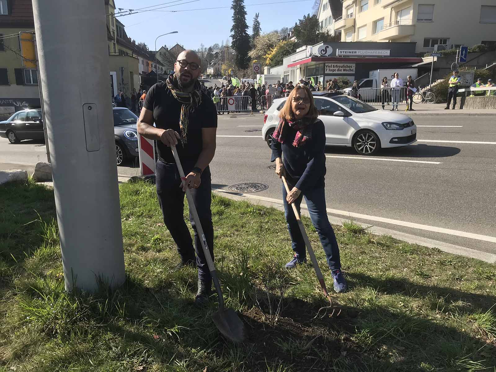 Eva Gut und Andrew Katumba pflanzten an der Rosengarten-Demo einen Rosenbusch. Ironischer Weise taten die damit vielleicht mehr für die Feinstaubreduktion als der Kanton mit seinem Milliardentunnel.